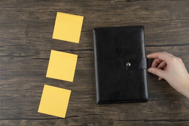 Ahşap arka planda not defteri olan sarı kare çıkartma. Yüksek kalite fotoğraf