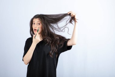 Beyaz arka planda fırçayla allık süren genç ve güzel bir model resmi. Yüksek kalite fotoğraf