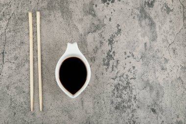 Geleneksel soya sosu ve yemek çubukları taştan arka planda. Yüksek kalite fotoğraf