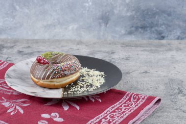 Çilekli ve mermer yüzeyine serpiştirilmiş bir tabak çikolatalı çörek. Yüksek kalite fotoğraf