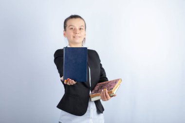 Beyaz arka plan üzerine ilginç bir kitap gösteren genç bir kızın portresi. Yüksek kalite fotoğraf