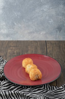 Ahşap masaya yerleştirilmiş lezzetli kadaif hamur işleri. Yüksek kalite fotoğraf