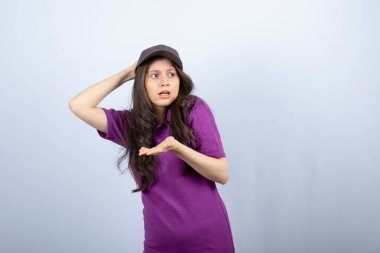 Mor üniformalı teslimatçı kızın portresi üzgün bir suratla duruyor. Yüksek kalite fotoğraf