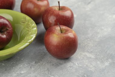 Taze kırmızı elmalar ve mermer arka planda boş kase. Yüksek kalite fotoğraf
