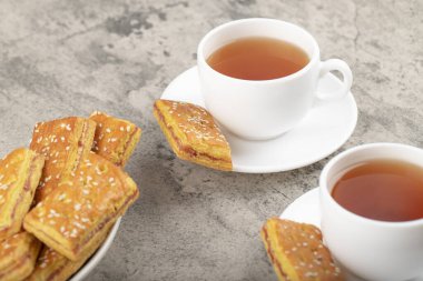 Taş masaya kraker konmuş beyaz çay fincanları. Yüksek kalite fotoğraf