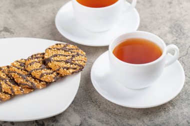 Beyaz tabak yulaflı çikolatalı bisküvi ve bir fincan çay. Yüksek kalite fotoğraf