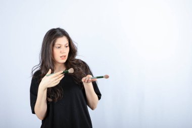 Beyaz arka planda fırçası olan genç ve güzel bir model. Yüksek kalite fotoğraf