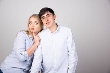 Gri arka planda kameraya poz veren genç bir çiftin portresi. Yüksek kalite fotoğraf