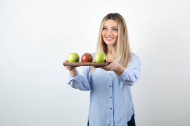 Elma tabağı tutan genç sarışın kadın portresi. Yüksek kalite fotoğraf