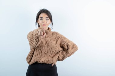 Beyaz arkaplanı gösteren örgü kazaklı güzel bir kadın fotoğrafı. Yüksek kalite fotoğraf