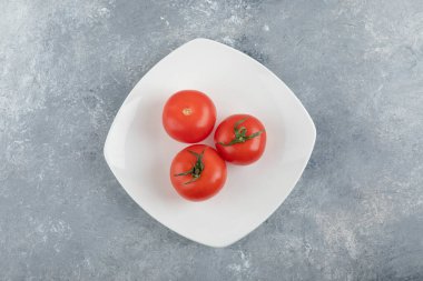 Taş zeminde üç taze kırmızı domates tabağı. Yüksek kalite fotoğraf