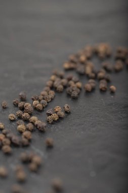 Siyah yüzeye dağılmış organik siyah karabiber yığını. Yüksek kalite fotoğraf