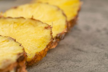 Taş zemine yerleştirilmiş lezzetli ananaslı dilimler. Yüksek kalite fotoğraf