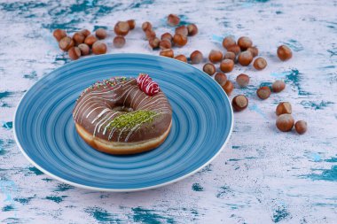 Çikolatalı çörek ve beyaz yüzeyde kabuklu fındık. Yüksek kalite fotoğraf