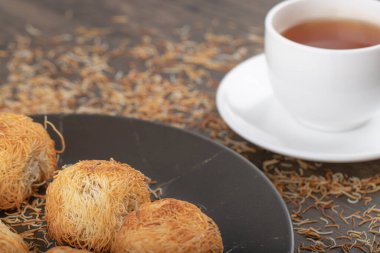 Tahta masaya beyaz bir fincan sıcak çay konmuş Türk tatlıları. Yüksek kalite fotoğraf