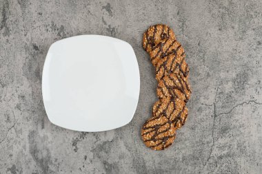 Taş zeminde yulaf ezmeli kurabiyeler olan boş bir tabak. Yüksek kalite fotoğraf