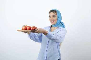 Elinde ahşap domates tahtası olan mendilli güzel bir kadın resmi. Yüksek kalite fotoğraf