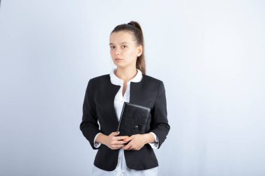 Beyaz arka planda duran defterli genç bayan öğretmenin portresi. Yüksek kalite fotoğraf