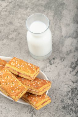 Susam tohumlu krakerler ve bir sehpaya konmuş cam sürahi süt. Yüksek kalite fotoğraf