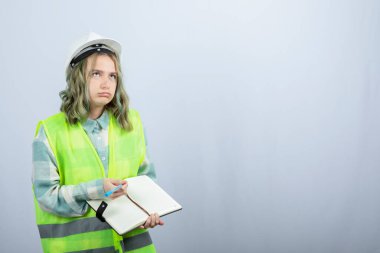 Not defterine ne yazacağını düşünen genç kadın mühendisin fotoğrafı. Yüksek kalite fotoğraf