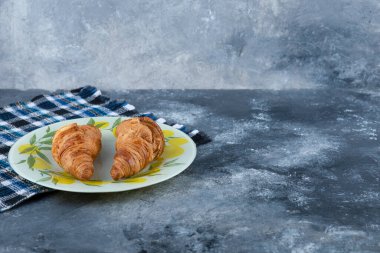 Taze ve lezzetli kruvasanlar taş masaya konmuş. Yüksek kalite fotoğraf