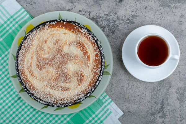 Taş bir masanın üzerine bir fincan siyah çay ile bir tabak lezzetli turta. Yüksek kalite fotoğraf