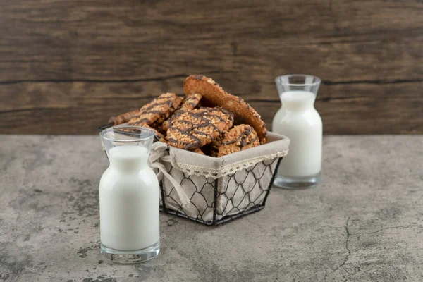 Sepetinde çikolata jöleli leziz çoklu tahıllı kurabiyeler ve iki bardak süt kavanozu. Yüksek kalite fotoğraf