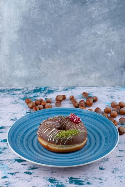 Çikolatalı çörek ve beyaz yüzeyde kabuklu fındık. Yüksek kalite fotoğraf