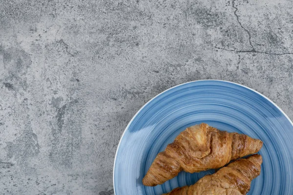 Taştan bir arka planda iki sade kruvasan tabağı. Yüksek kalite fotoğraf