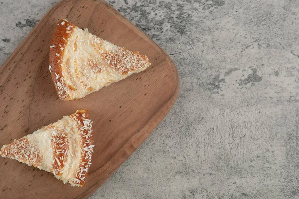 Tahtaya hindistan cevizi serpiştirilmiş iki dilim pasta. Yüksek kalite fotoğraf