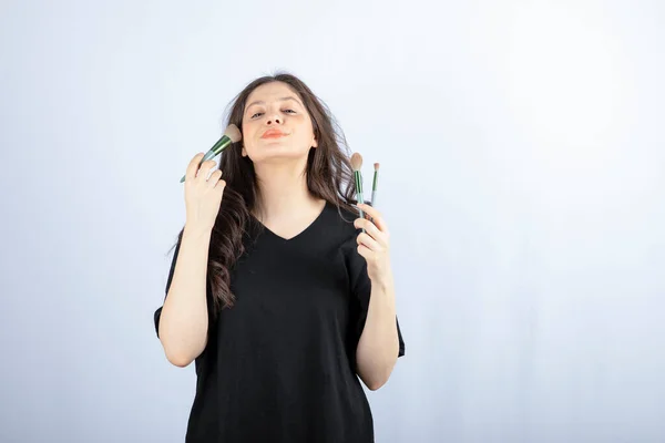 Imagem Jovem Modelo Bonito Aplicando Maquiagem Com Escova Fundo Branco — Fotografia de Stock