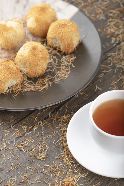 Tahta masaya beyaz bir fincan sıcak çay konmuş Türk tatlıları. Yüksek kalite fotoğraf