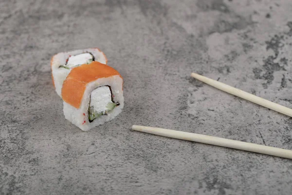 Geleneksel Philadelphia suşisi, taş yüzeyinde somon balığı ile yuvarlanır. Yüksek kalite fotoğraf