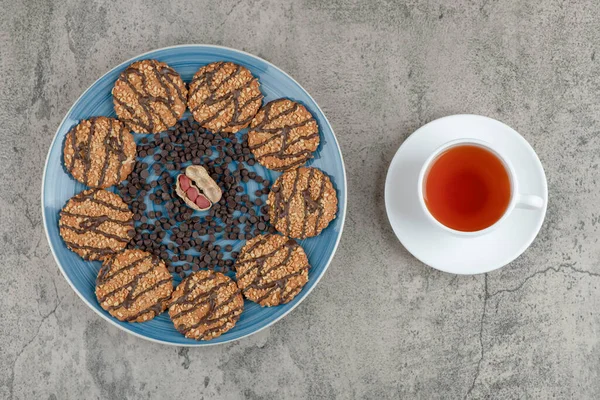 Çikolatalı bisküvi ve mermer arka planda bitki çayı ile mavi tabak. Yüksek kalite fotoğraf