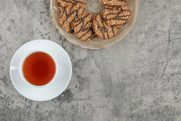 Susamlı kurabiyeler ve mermer yüzeyde bir fincan çay. Yüksek kalite fotoğraf