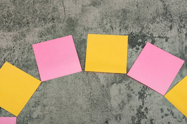 Taş bir arka planda turuncu ve pembe kare çıkartmalar. Yüksek kalite fotoğraf