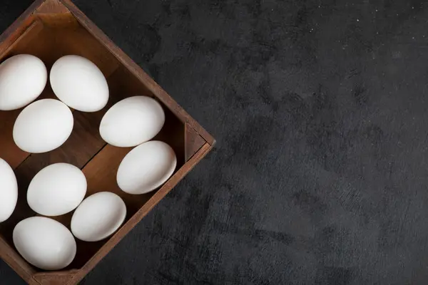 Siyah arka planda organik çiğ yumurta dolu tahta kutu. Yüksek kalite fotoğraf