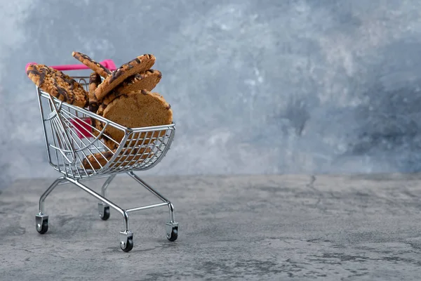 大理石の背景に置かれたおいしいクッキーの小さなピンクのカート 高品質の写真 — ストック写真