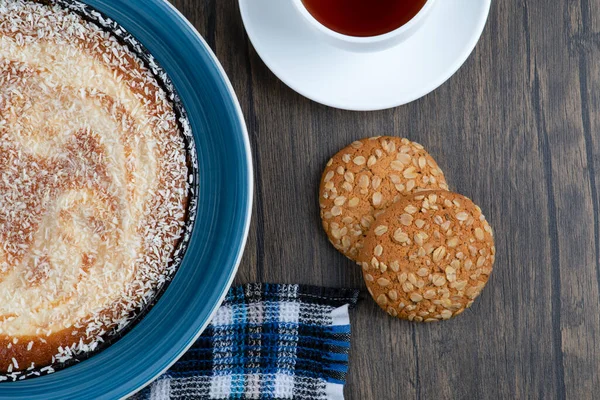 Tahta masaya konmuş turta ve çayla yerleştirilmiş tahıllı yulaf ezmeli kurabiyeler. Yüksek kalite fotoğraf