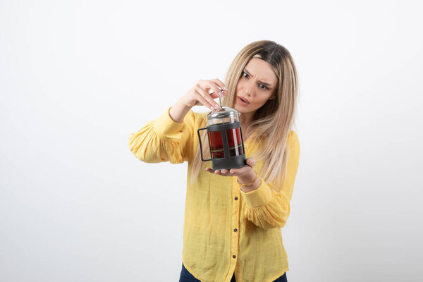 Image of a young pretty woman model holding a teapot . High quality photo