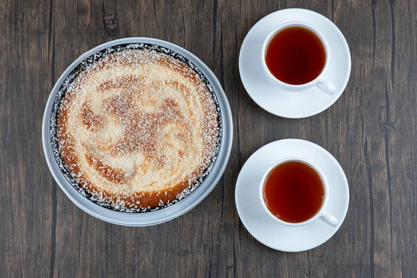 Tahta bir masaya siyah çay konmuş bir tabak lezzetli turta. Yüksek kalite fotoğraf
