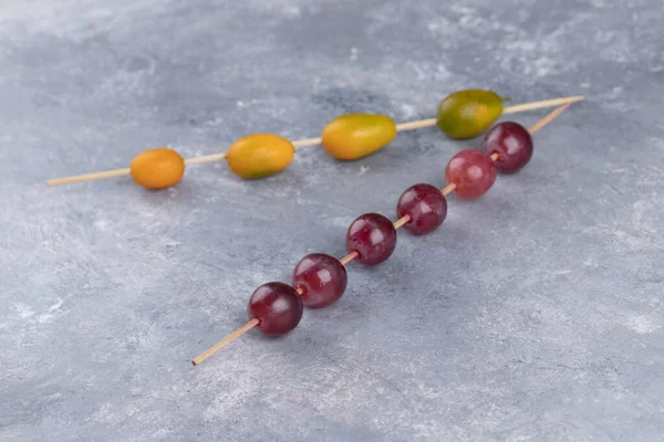 Palillos Con Kumquats Frescos Uvas Sobre Fondo Mármol Foto Alta — Foto de Stock