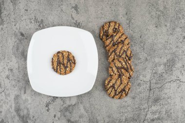 Beyaz tabakta çikolata soslu yulaflı kurabiye. Yüksek kalite fotoğraf