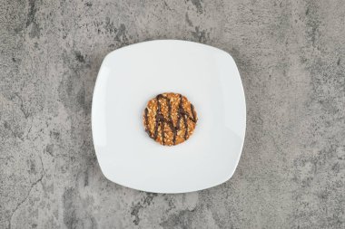 Beyaz tabakta çikolata soslu yulaflı kurabiye. Yüksek kalite fotoğraf