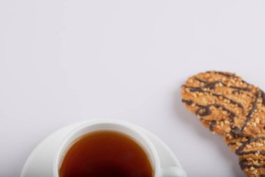 Beyaz masaya çok tahıllı kurabiyeler konmuş beyaz bir fincan sıcak çay. Yüksek kalite fotoğraf