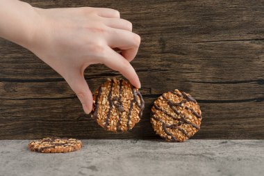 Taze pişmiş yulaf ezmeli kurabiyeler serpiştirilmiş kadın eli. Yüksek kalite fotoğraf