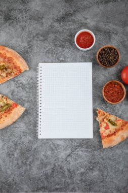 Lezzetli peynirli pizza dilimleri, baharatlar ve arka planda boş kağıt. Yüksek kalite fotoğraf