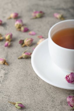 Taş yüzeyinde kurumuş güller olan bir fincan siyah sıcak çay. Yüksek kalite fotoğraf