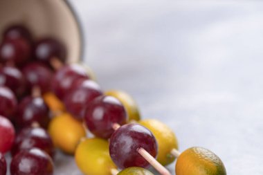 Olgun kırmızı üzümler ve mermer arka planda kumkatlarla dolu bir kupa. Yüksek kalite fotoğraf