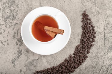 Bir yığın koyu çikolata parçacıklı damla ve masada bir fincan siyah çay. Yüksek kalite fotoğraf